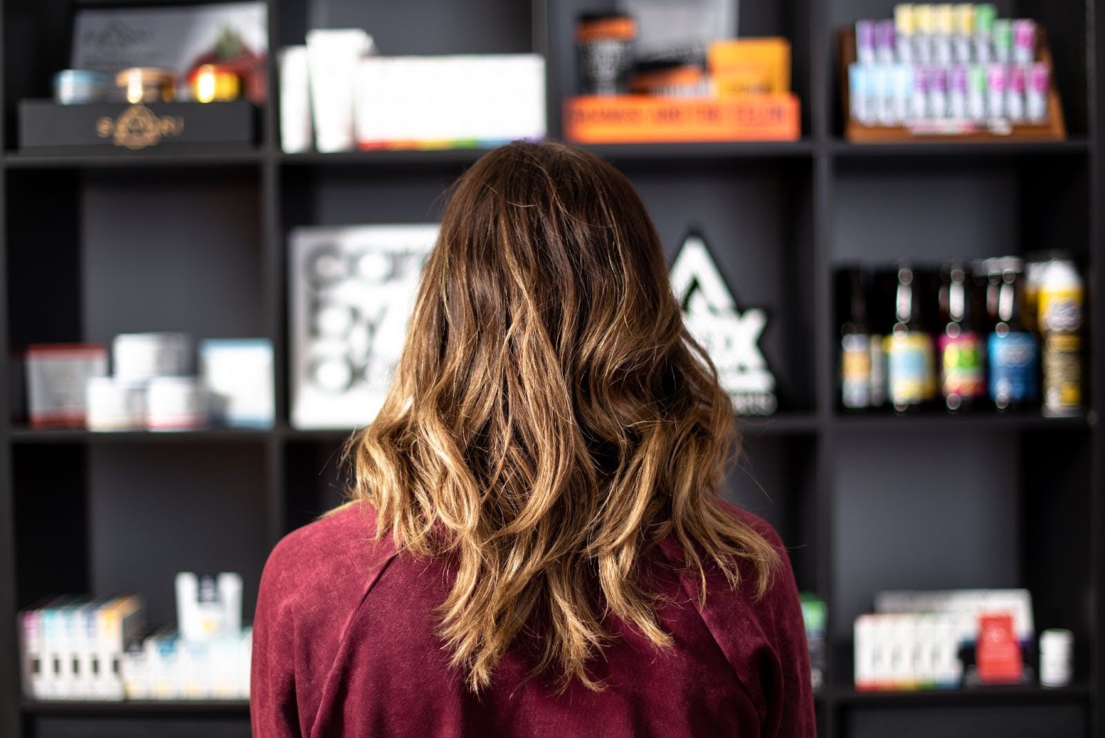 Woman looking at shelf of Cannabis packaging